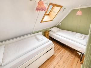two beds in a small room with a window at Beachhouse Syðrugøta in Syðrugøta