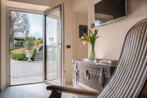 a living room with a chair and a glass door at Casale Raffaello B&B Como in Albese Con Cassano