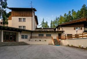 a large house with a driveway in front of it at Hotel Paolino in Cavareno