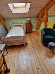 a bedroom with a bed and a chair and a skylight at gîte de Véreuges in Saint-Julien-des-Chazes