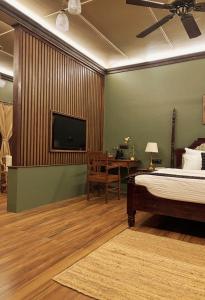 a bedroom with a bed and a flat screen tv at Kalimpong Bungalow in Kalimpong