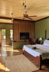 a bedroom with two beds and a ceiling fan at Kalimpong Bungalow in Kalimpong