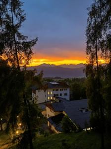 a sunset over a city with mountains in the background at Hotel Paolino in Cavareno