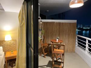 a room with a balcony with a table and chairs at Flat Tropical Hotel Com Varanda Vista Espetacular in Manaus