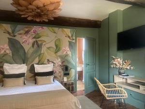 a bedroom with a bed with a flower mural on the wall at Art'Hotel & SPA Le Potin Gourmand in Cluny