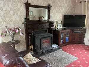 a living room with a fireplace and a television at Hillview House in Cootehill