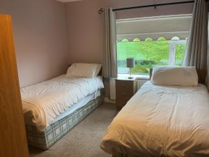 two beds in a room with a window at Hillview House in Cootehill