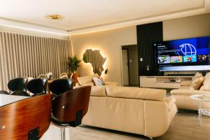 a living room with a couch and a tv at Villa Limonero in Naboomspruit