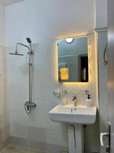 a bathroom with a sink and a shower with a mirror at Welcome Home 102 SaintLouis in Saint-Louis