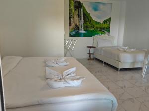two beds in a room with a painting on the wall at 449 Airport Phuket in Nai Yang Beach
