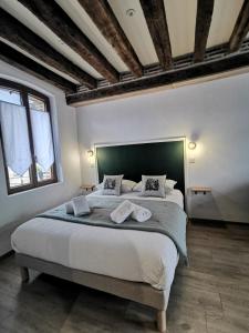 a bedroom with a large bed with a green headboard at Les Nuitées de Bois Renaud Chambre d'Hôtes LA FORET in Marcilly-en-Gault