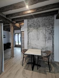 a table and chairs in a room with a mural at Les Nuitées de Bois Renaud Chambre d'Hôtes LA FORET in Marcilly-en-Gault +20 photos
