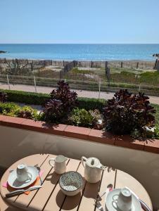 a table with a view of the ocean from a balcony at Studio Vue mer, Piscine, Wifi, Climatisation, Parking privé, Terrasse 1ère ligne - La Coulée Douce in Frontignan