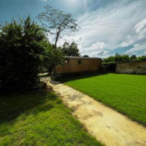 a field of green grass next to a building at La Roulotte du Maine SAINTES in Saintes +5 photos
