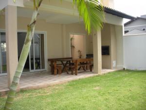 a patio with a wooden table in a house at Fragata Azul Casa in Bombinhas