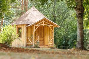 a small wooden hut with a thatch roof at L'Envol - Oasis Ressource in Eyliac