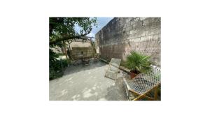 a patio with two chairs and a brick wall at La Roulotte du Maine SAINTES in Saintes