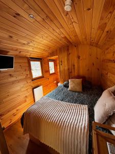 a bedroom with a bed in a wooden cabin at La Roulotte du Maine SAINTES in Saintes