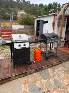 a grill and a picnic table on a deck at Finca El Escondite in Olocau