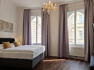 a bedroom with a bed and a chandelier at Pension Mozart - Vienna Center, Self Check-in in Vienna