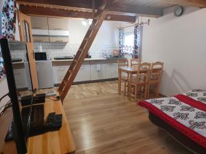 a kitchen and dining room with a table and chairs at Domek MIŚ Na Stoku in Tylicz