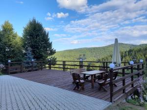 a wooden deck with a table and an umbrella at Domek MIŚ Na Stoku in Tylicz