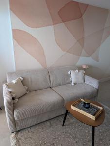 a living room with a couch and a table at Studio Vue mer, Piscine, Wifi, Climatisation, Parking privé, Terrasse 1ère ligne - La Coulée Douce in Frontignan +36 photos