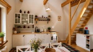 a kitchen with white cabinets and a table and chairs at Rusínska chyža in Ulič