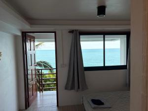 a room with a bedroom with a view of the ocean at Noahs Ark Beach in Nathon Bay