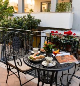 a table with a plate of food on a balcony at Gloeden House in Taormina