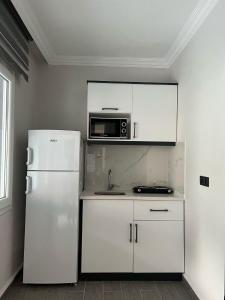 a kitchen with a white refrigerator and a microwave at Lilia Homes in Fethiye