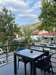 a table and chairs on a balcony with a view of a town at Lilia Homes in Fethiye
