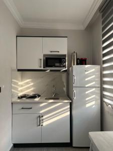 a kitchen with a white refrigerator and a microwave at Lilia Homes in Fethiye +10 photos