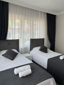 a hotel room with two beds and a window at Lilia Homes in Fethiye