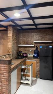 a kitchen with a black refrigerator and a counter at Aby's Guest House in Tlekung