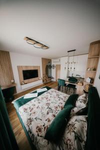 a bedroom with a bed with green pillows on it at D Mol Studio apartman in Tuzla
