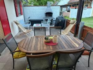 a wooden table and chairs on a patio at La Hiška Čatež with Tickets - each guest gets 2 entries per day in Čatež ob Savi