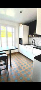 a kitchen with white cabinets and a table in it at Cyrus House - maison complète 90m2 in Le Mans