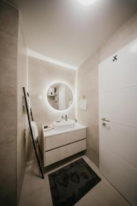 a white bathroom with a sink and a mirror at D Mol Studio apartman in Tuzla +17 photos