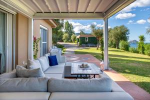 a patio with a white couch and a table at Villa Torre Conca Cefalu Coast in Finale