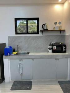 a kitchen counter with a sink and a window at A&E Transient Rooms in Calatagan