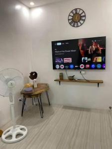 a room with a fan and a table and a tv at A&E Transient Rooms in Calatagan
