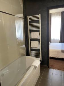 a bathroom with a bath tub and a bedroom at Hotel Ajoncs d'Or in Saint Malo +113 photos
