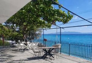 a patio with a table and chairs and the ocean at Sea View Borsh Albania in Borsh