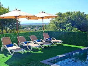 a group of chairs and umbrellas next to a pool at Horizon Crown Rooms Ulcinj in Briska Gora