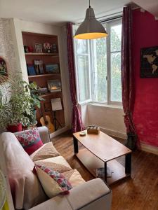a living room with a couch and a table at 11 Steps Rustic Charming Flat in Normandy in Aubusson