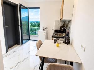 a kitchen with a counter and a table with chairs at Horizon Crown Rooms Ulcinj in Briska Gora
