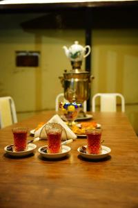 a wooden table with four plates of food on it at Casa Serena Sheki in Sheki