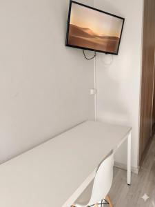 a white desk with a television on a wall at Residencia Albergue Jaca in Jaca