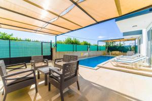 a patio with a table and chairs and a swimming pool at Villa Horizon in Ortaca